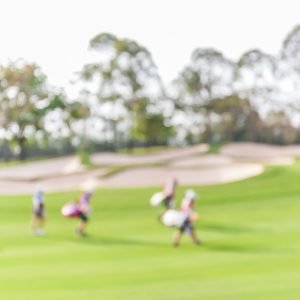 BLurred Image Of Golfers Walking The Fairway On A Golfcourse With A geothermal HVAC system
