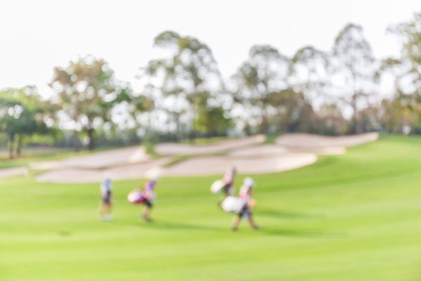 BLurred Image Of Golfers Walking The Fairway On A Golfcourse With A geothermal HVAC system