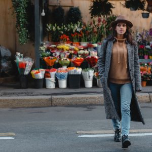 Woman Crossing a Street in Front of a Flower Shop Representing Clean Geothermal Energy Systems