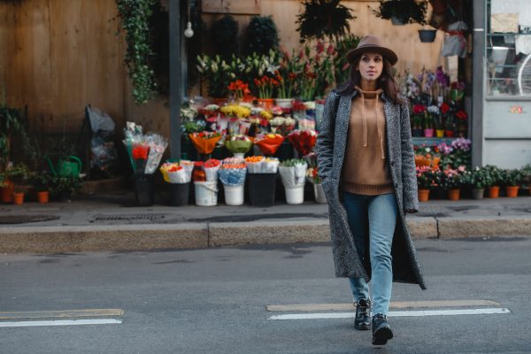 Woman Crossing a Street in Front of a Flower Shop Representing Clean Geothermal Energy Systems
