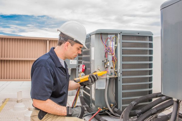 Professional HVAC Repair Technician Working On Air Conditioner