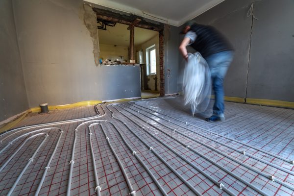 Technician Laying Tubing For A Hydronic Radiant Floor Heating System