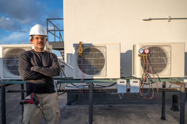 Technician standing next to Commercial Residential HVAC Services Conventional And Geothermal Systems