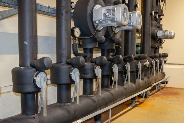 Industrial geothermal HVAC system piping and loop components during maintenance service in a Metro Atlanta mechanical room
