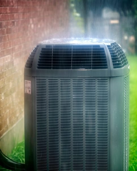 Outdoor air conditioning unit beside a residential home in Buckhead, Atlanta during rainy conditions, highlighting the need for air conditioning repair, spring HVAC maintenance, and system efficiency before peak summer temperatures.