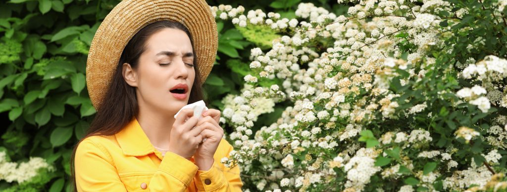 Woman experiencing spring allergies in Serenbe, highlighting pollen impact on indoor air quality and HVAC system performance