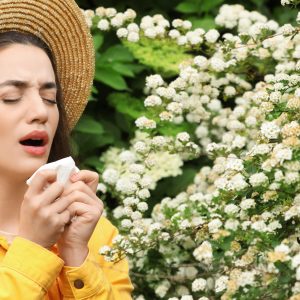 Woman experiencing spring allergies in Serenbe, highlighting pollen impact on indoor air quality and HVAC system performance