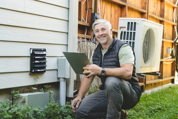 HVAC technician inspecting an outdoor air conditioning unit during an Atlanta AC repair service call.