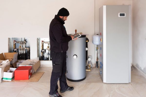 Technician servicing residential geothermal HVAC system during spring maintenance in Decatur and Druid Hills