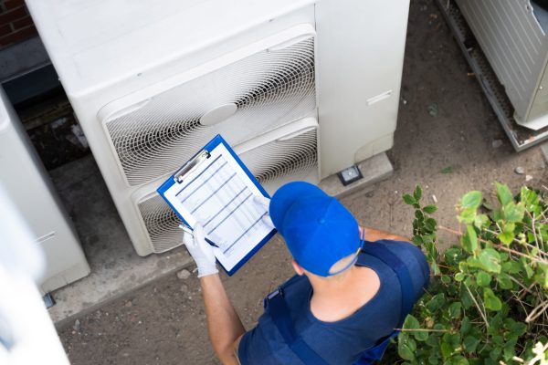 Atlanta Technician performing a commercial heat pump inspection and maintenance checklist to prevent cooling failures