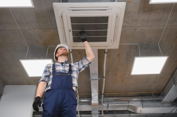 Atlanta Technician inspecting a commercial HVAC air filter to improve airflow, cooling performance, and efficiency