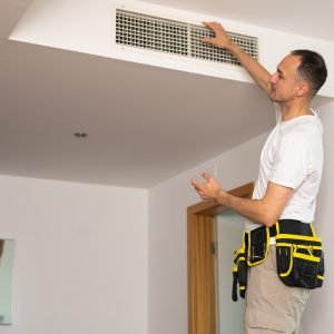 HVAC technician checking airflow and vents during ClimateMaster geothermal fault code diagnostics in Metro Atlanta