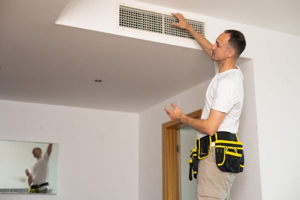 HVAC technician checking airflow and vents during ClimateMaster geothermal fault code diagnostics in Metro Atlanta