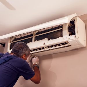 EcoMech technician diagnosing an Atlanta air conditioner leaking water during humid summer weather