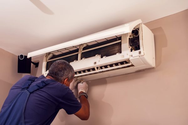 EcoMech technician diagnosing an Atlanta air conditioner leaking water during humid summer weather