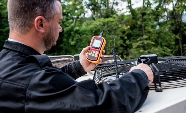 Ecomech HVAC technician testing outdoor AC unit airflow and cooling performance during residential HVAC service in Atlanta